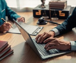 Lawyers discuss documents, contracts and legal entities in a law office, providing advice, justice, consulting on the law with hammers and scales on the table.