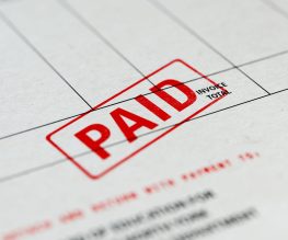 Close-up picture of an invoice with red paid stamp with selective focus. Great use for financial concepts.